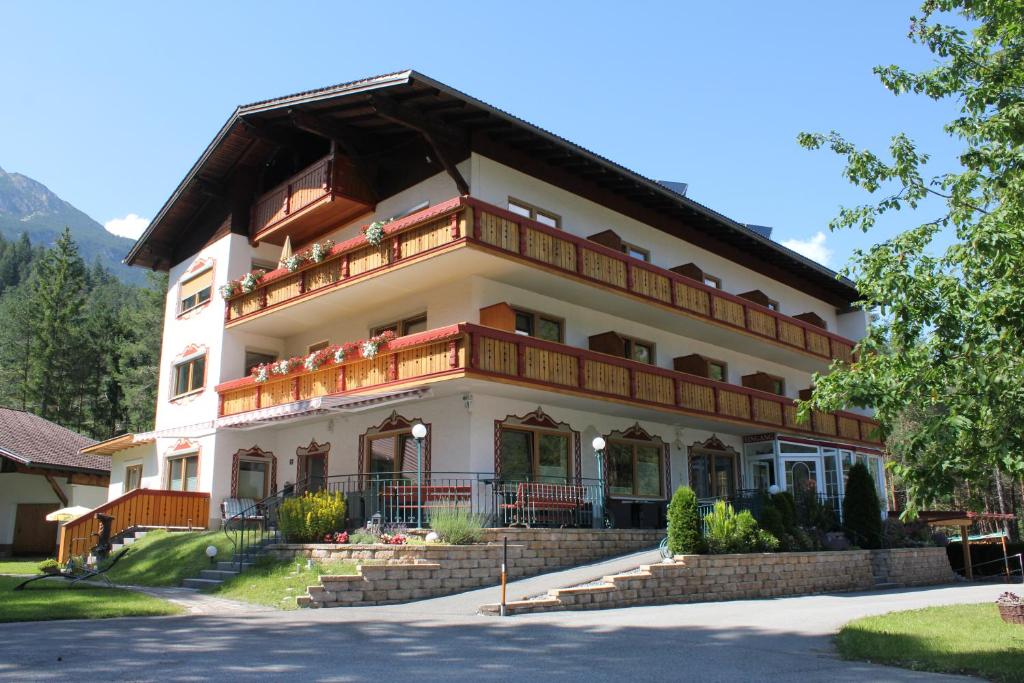 duży biały budynek z balkonem w obiekcie Hotel Garni Waldhof - Wohlfühlen am Lech w mieście Stanzach