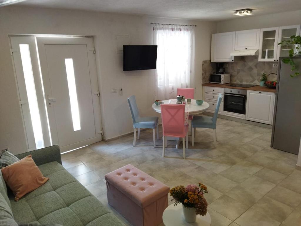 a living room with a couch and a table and a kitchen at Holiday home Silva in Peruški