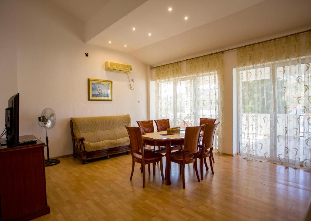 a dining room with a table and chairs and a couch at apartment Summer vip in Bar