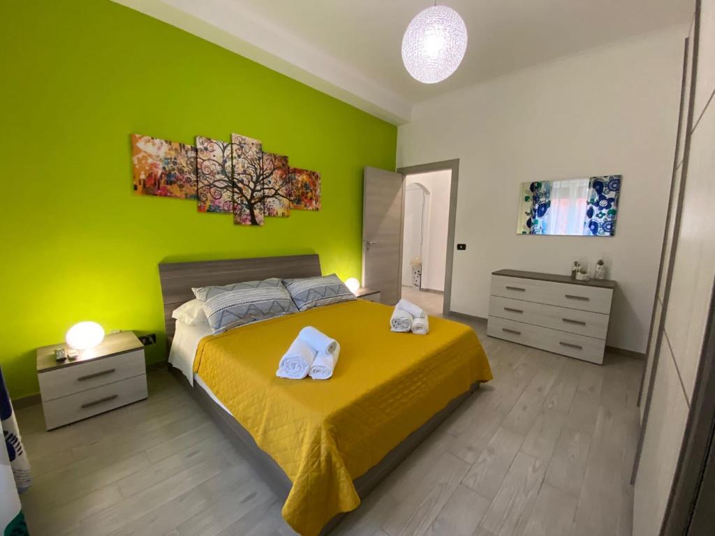 a green bedroom with a bed with two white shoes on it at Mimma’s house Monteverde in Rome