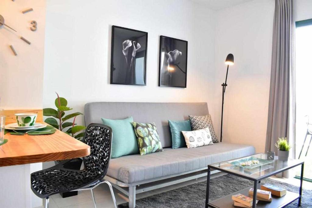 uma sala de estar com um sofá e uma mesa em Holyhome apartment 204 em Costa Teguise