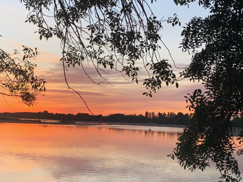 vista para um lago ao pôr-do-sol em Les roses de l'Olivier em Les Rosiers