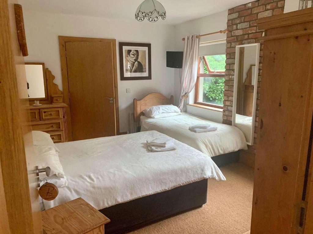 a bedroom with two beds and a window at Paul Arthurs Restaurant & Rooms - Kircubbin in Newtownards