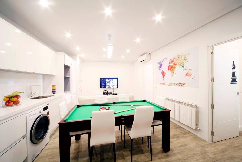 una cucina con tavolo da biliardo e armadietti bianchi di Luxury & Design Apartment Madrid Center 3BRM 3BTHR a Madrid