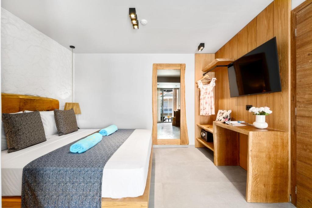 a bedroom with a bed and a flat screen tv at Emily's Luxury Suites in Pefkochori