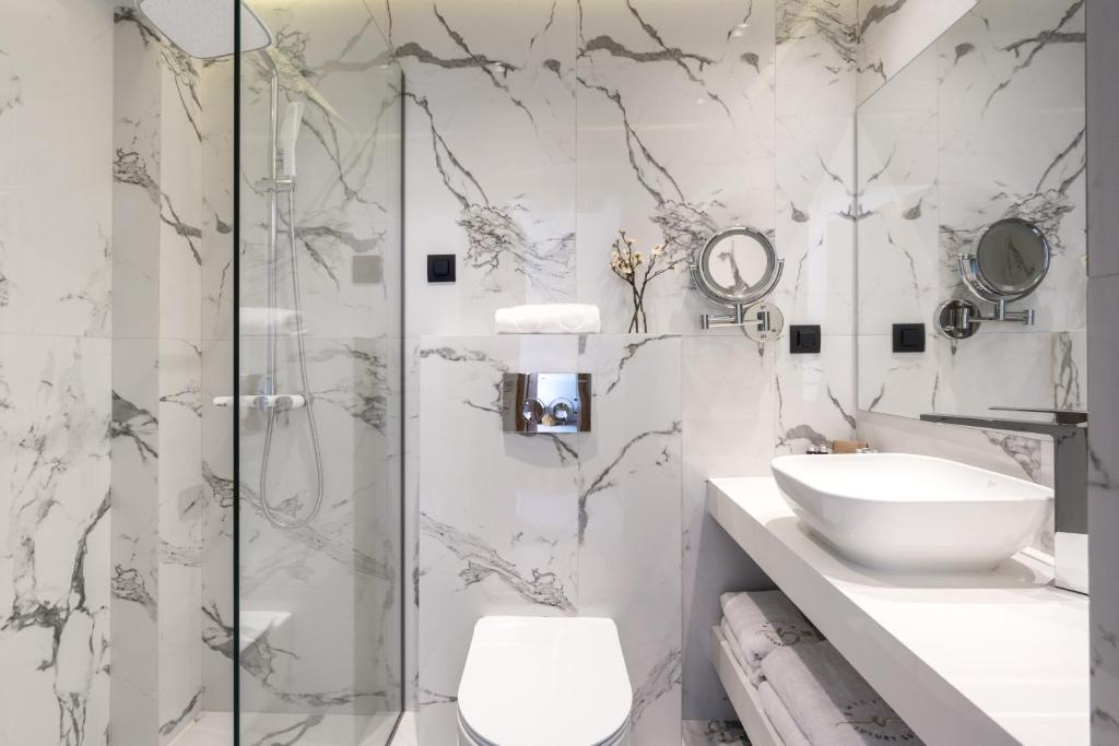 a bathroom with a shower and a toilet and a sink at Emily's Luxury Suites in Pefkochori