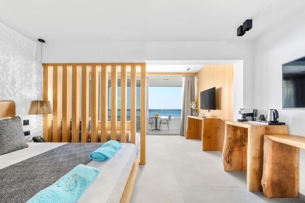 sypialnia z łóżkiem i widokiem na ocean w obiekcie Emily's Luxury Suites w mieście Pefkochori