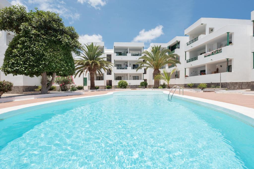 a swimming pool in front of a building at Lanzahost Casa Cala in Costa Teguise