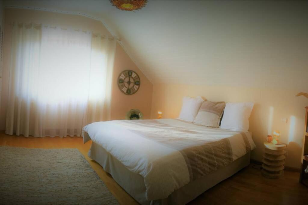 Schlafzimmer mit einem großen weißen Bett und einem Fenster in der Unterkunft MaNaLa "120 m2" in Algolsheim