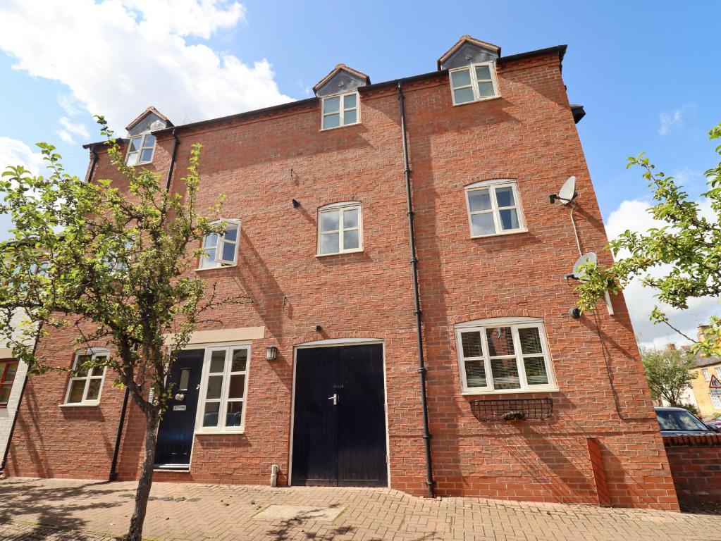 un gran edificio de ladrillo rojo con puerta en The Old Bakery, Apartment 5, en Shipston on Stour