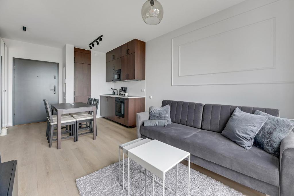 a living room with a couch and a table at Chlebova Deluxe 2 Gdańsk by Grand Apartments in Gdańsk