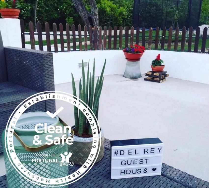 eine Uhr auf einer Terrasse mit einem Schild in der Unterkunft DEl Rey Guest House in Tomar