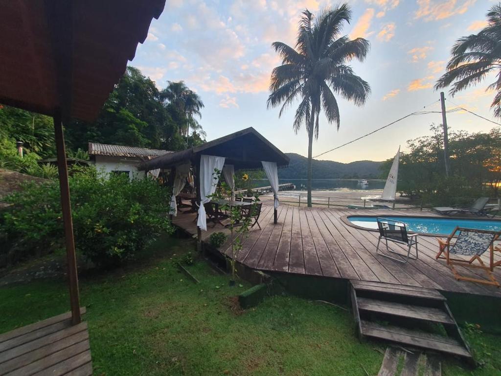 - une terrasse avec une table et des chaises à côté de la piscine dans l'établissement Club MV Saco do Céu, à Abraão