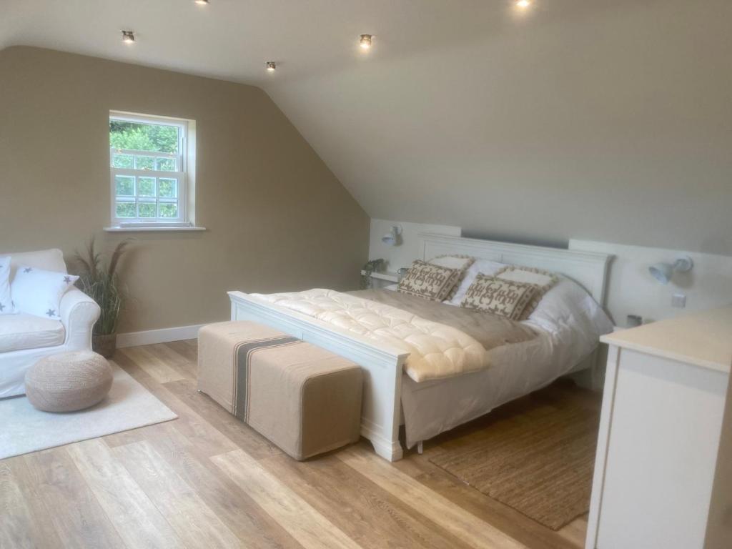 1 dormitorio con 1 cama grande y 1 silla en Nettleford, en Kelsall