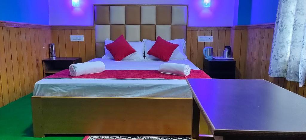 1 dormitorio con 1 cama grande con almohadas rojas en The Lachung Inn en Lachung