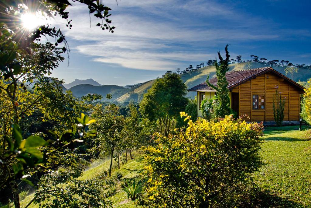 une maison en bois au milieu d'un champ dans l'établissement Pousada Nó da Madeira, à Visconde de Mauá