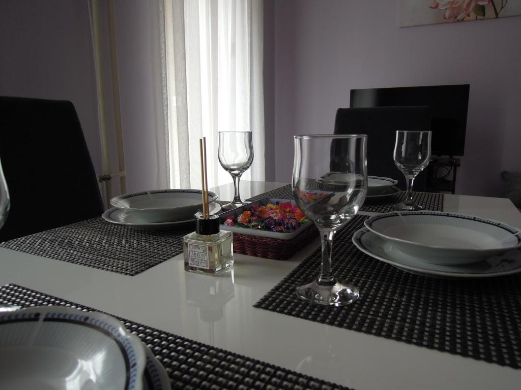 un tavolo con bicchieri da vino e piatti di Classic Apartment a Novi Sad