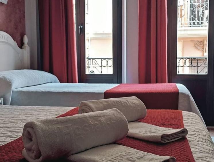 a hotel room with two beds with towels on them at Hostal Sonia Granada in Granada