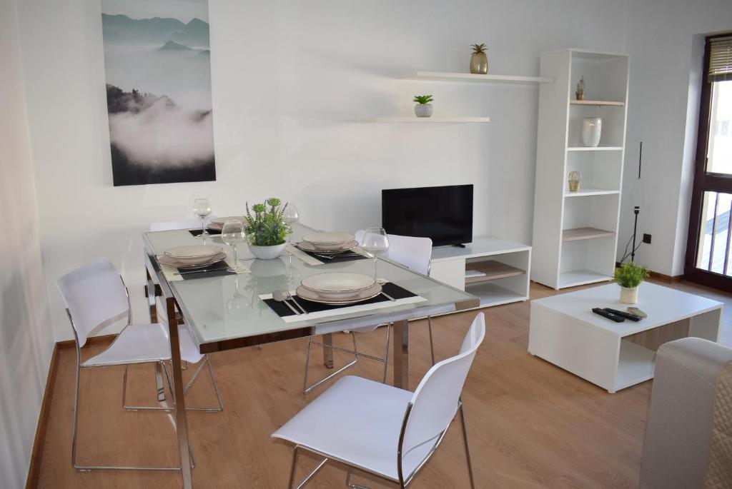 ein weißes Esszimmer mit einem Tisch und Stühlen in der Unterkunft Terreiro da Erva House in Coimbra