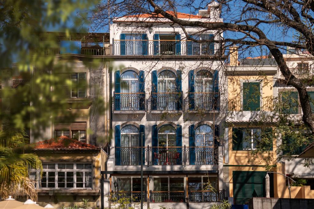 an old building with blue windows and balconies at Madeira Gems Apartments in Funchal