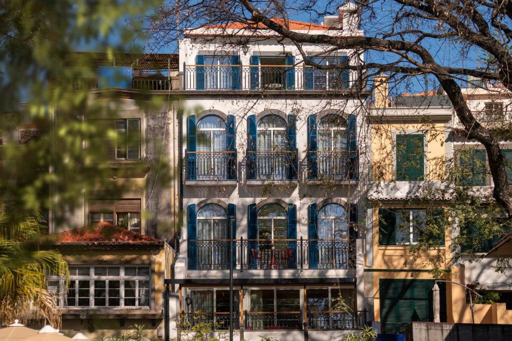 een oud gebouw met blauwe ramen en balkons bij Madeira Gems Apartments in Funchal
