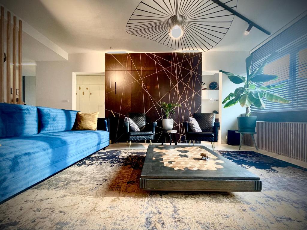 ein Wohnzimmer mit einem blauen Sofa und einem Tisch in der Unterkunft Desk Till Dawn in Gent