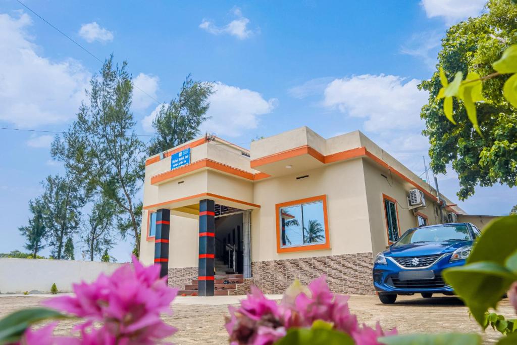 a house with a car parked in front of it at Hotel Sahil Inn in Mandarmoni