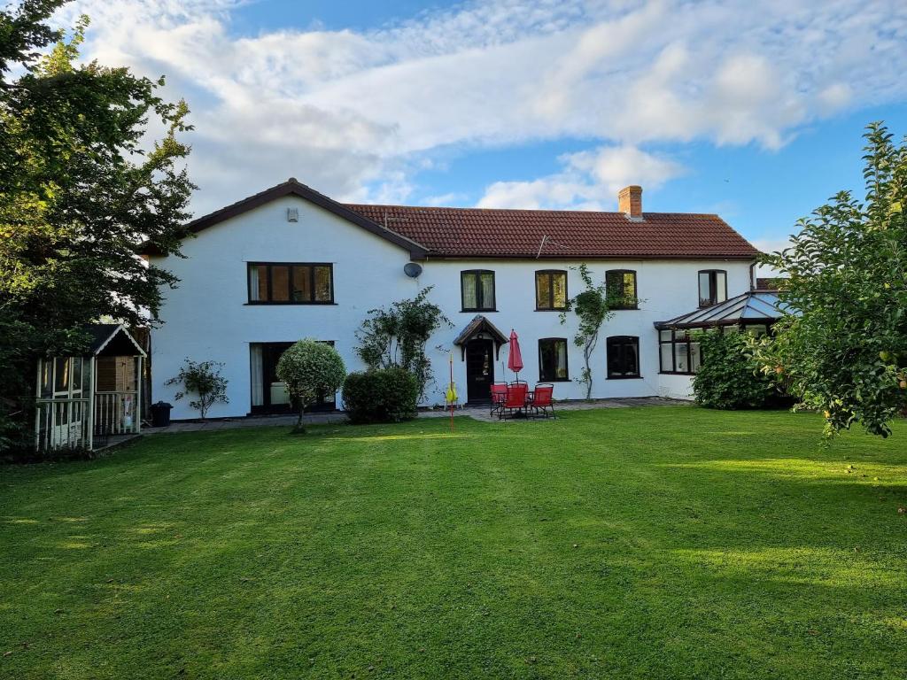 a large white house with a large yard at Burnt House Farm in Highbridge