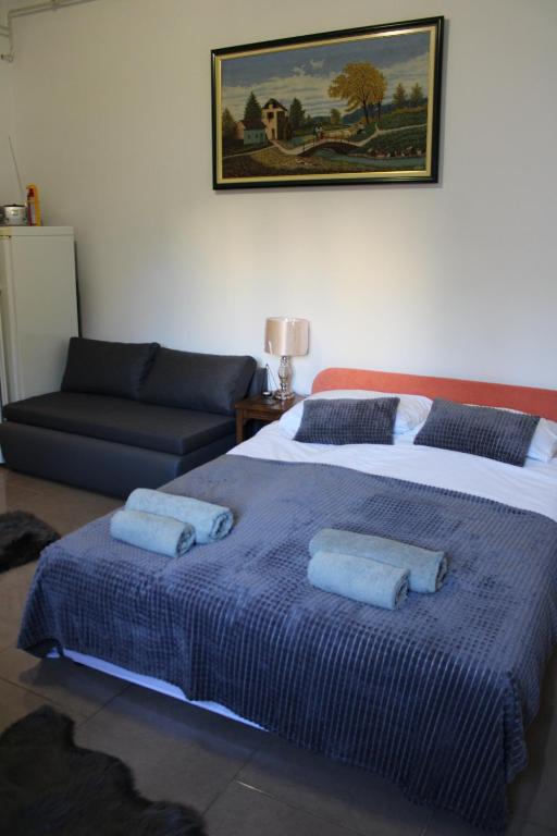ein Schlafzimmer mit einem großen Bett und einem Sofa in der Unterkunft Studio apartman Hinko in Ðakovo