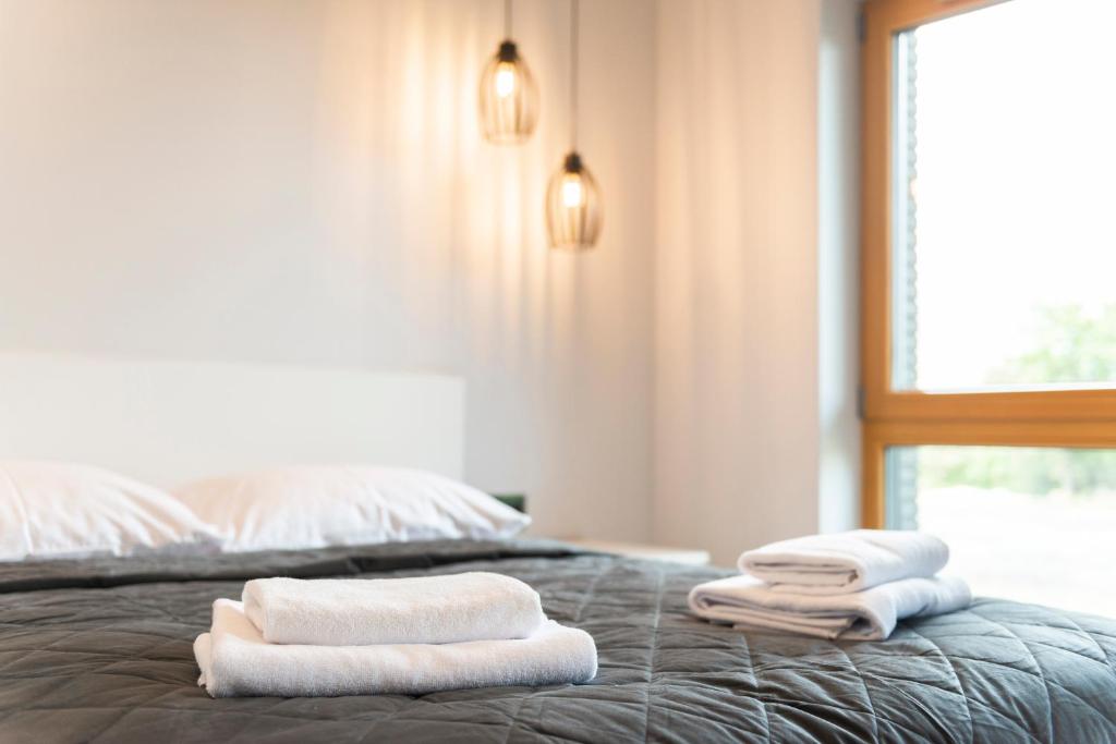 a bed with three towels on top of it at Old Town Nadmotławie - Sauna & Gym I 10min deptak in Gdańsk