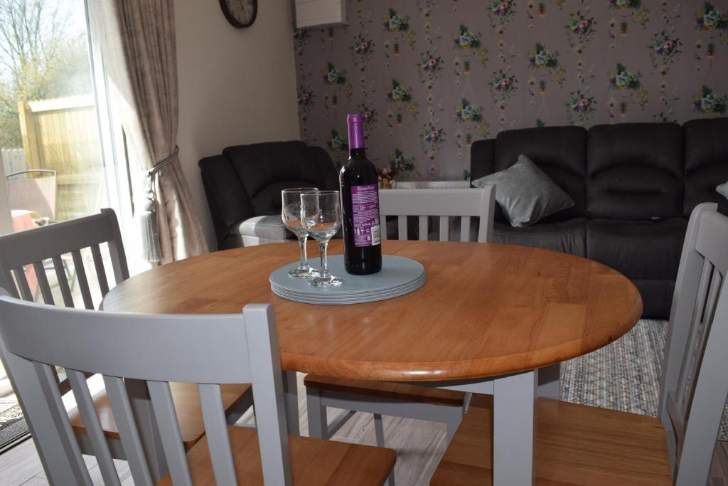 a table with a bottle of wine and two glasses on it at Orchardgrove apartment in Carlow