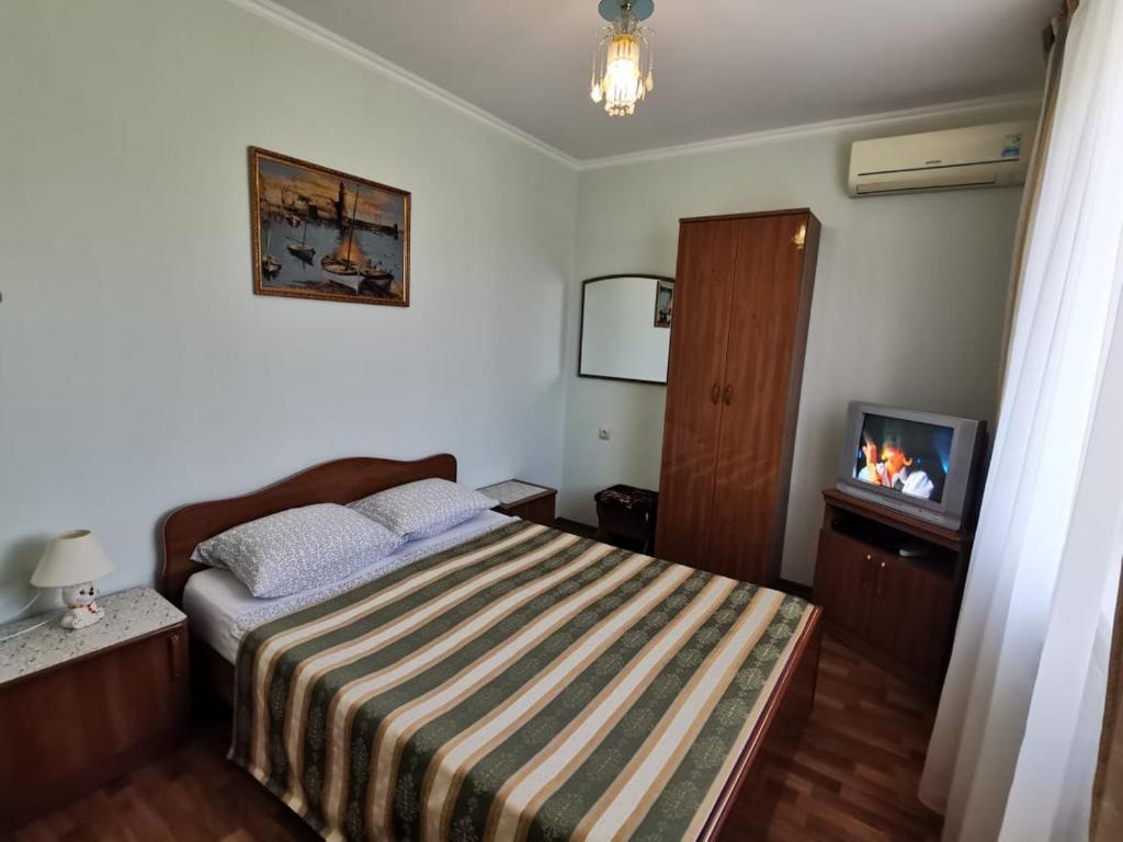 ゴルビツカヤにあるPoseydon Guest Houseの小さなベッドルーム(ベッド1台、テレビ付)