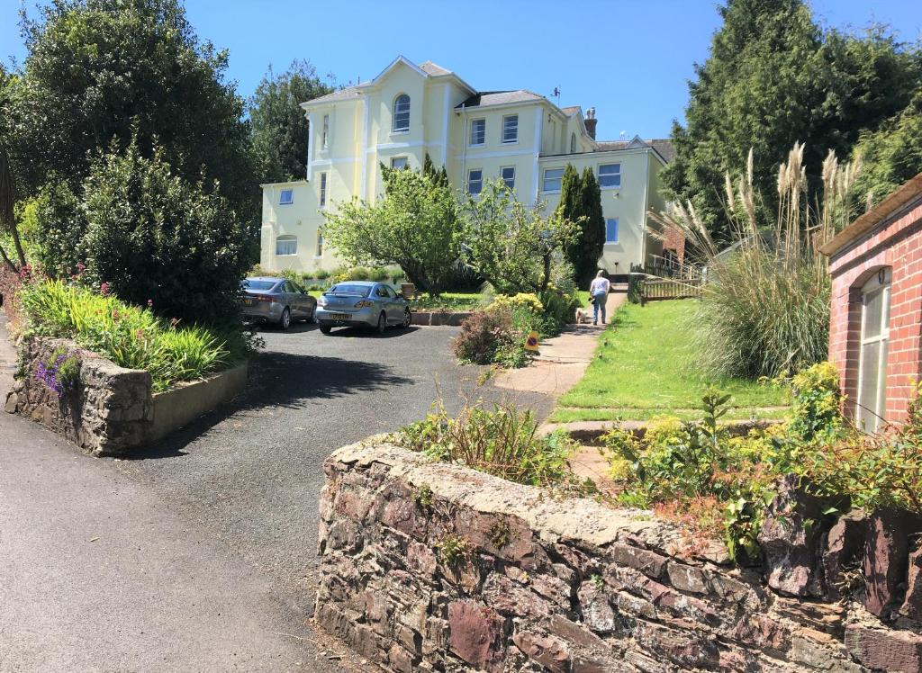 a large house with cars parked in a driveway at Chelston Dene Holiday Apartments in Torquay