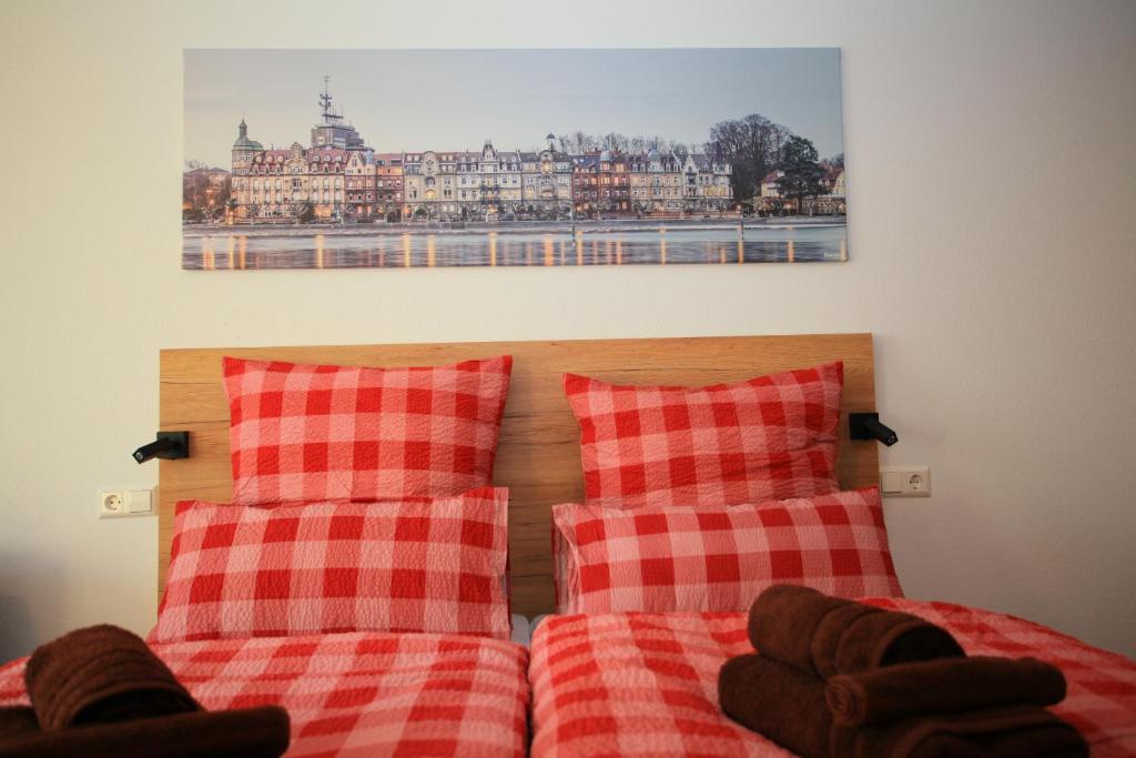 um quarto com 2 camas com almofadas vermelhas e brancas em Überlinger See-Apartments Über-See Apartment 3 em Überlingen