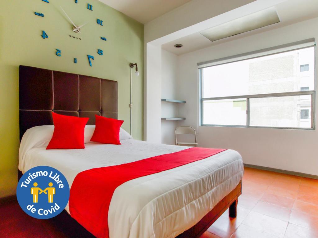 um quarto com uma cama grande e um relógio na parede em Hotel Allende 104 em Chihuahua