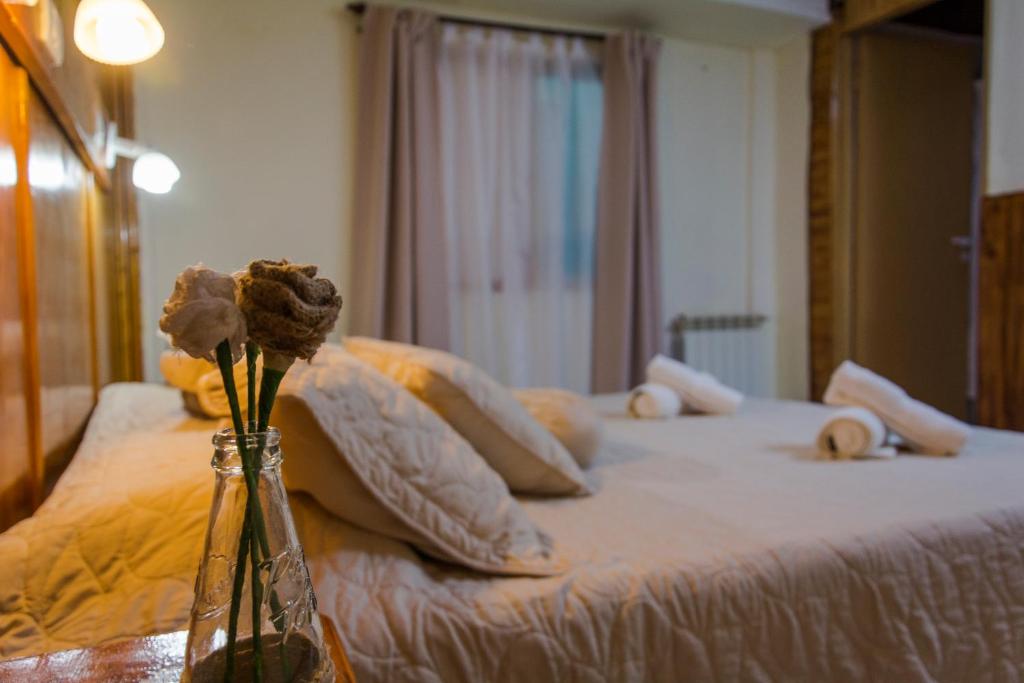 Un dormitorio con una cama con flores. en Hostel Buenos Aires, en El Calafate