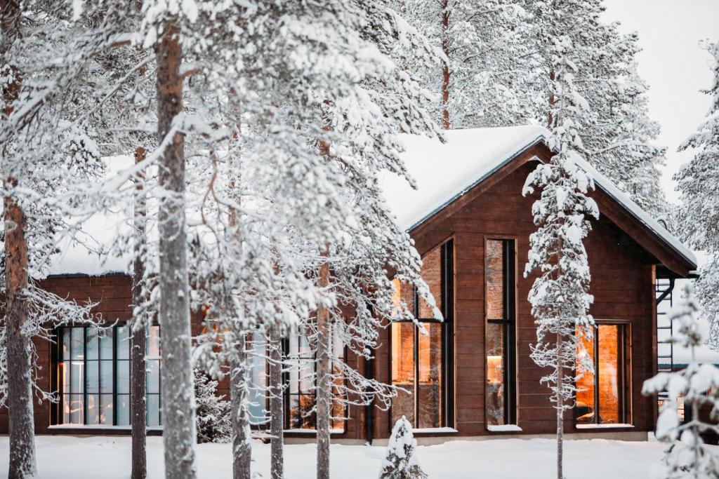 a house in the snow with trees at Raanakka House - Premium Villa at Levi in Levi