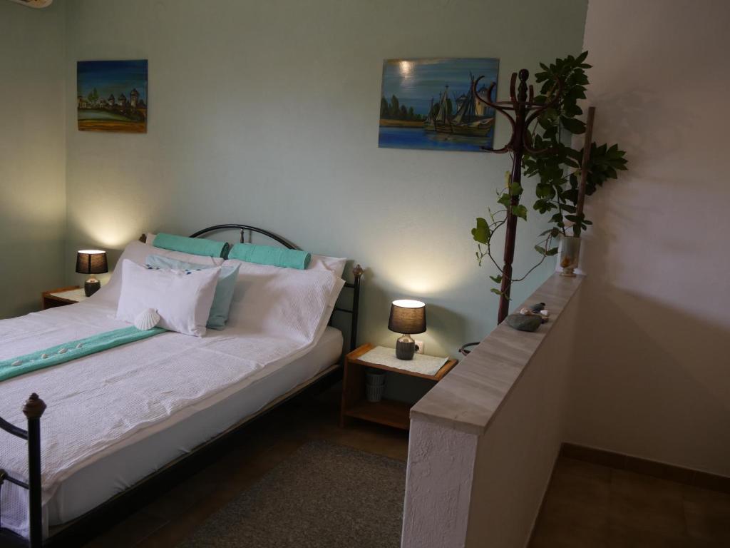 Helios Rhodos Apartments في Koskinou: غرفة نوم مع سرير وزرع الفخار