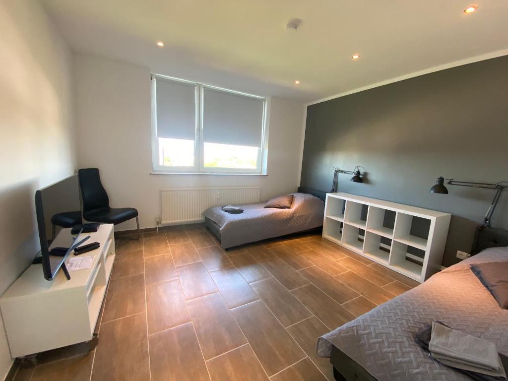 a bedroom with two beds and a desk and a chair at Duisburg von oben 3,5 Zimmer 8.OG frisch saniert in Duisburg