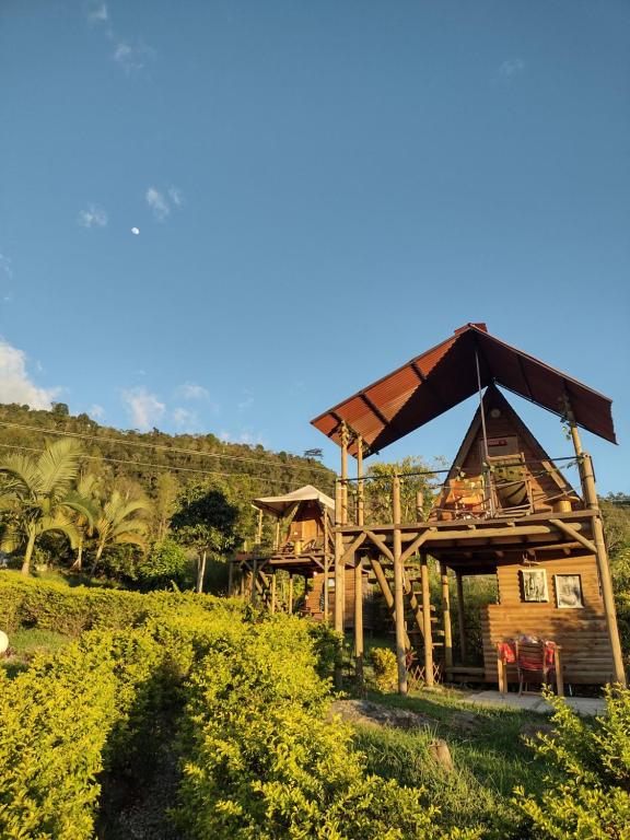 Casa de madera con techo de paja en VILLA DE LOS ANGELES GLAMPING, en Anolaima
