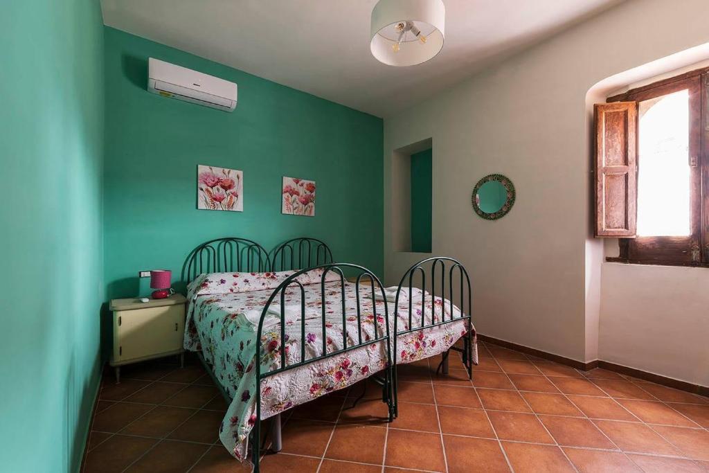ein Schlafzimmer mit einem Bett in einem Zimmer mit grünen Wänden in der Unterkunft Borgo San Lorenzello in San Lorenzello