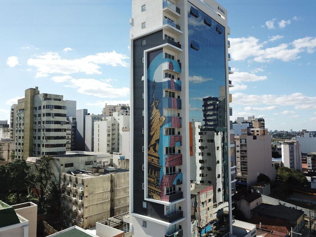 een hoog gebouw met een bord erop in een stad bij Mood Independência - Aptos centrais e completos in Passo Fundo