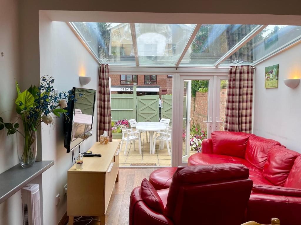 - un salon avec un canapé rouge et une table dans l'établissement Somers House - pet friendly & parking, à Portsmouth
