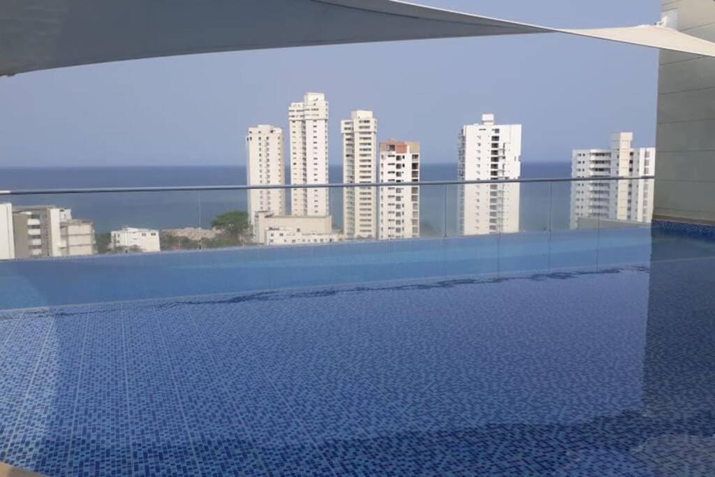 a swimming pool with a view of some tall buildings at Bonito y cómodo apartamento en el Rodadero. in Gaira