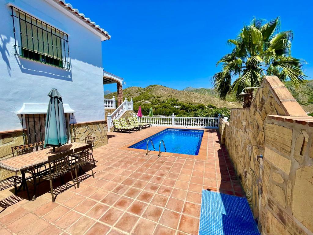 een patio met een zwembad en een huis bij Villa Nuria in Frigiliana