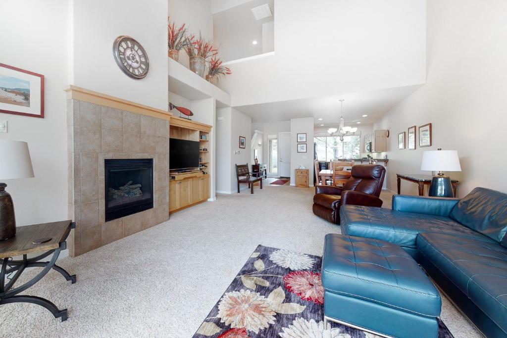 a living room with a blue couch and a fireplace at Pines and Blue Skies in Redmond