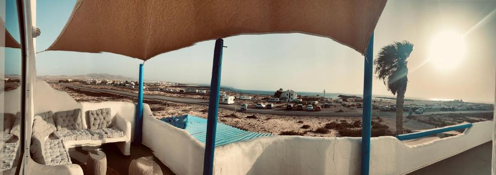 uma vista para uma praia debaixo de um guarda-sol em Azzurro house em Cotillo