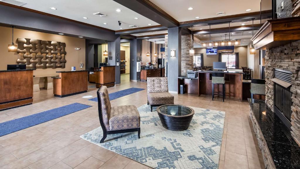 a lobby of a hotel with chairs and a bar at Best Western Plus Williston Hotel & Suites in Williston