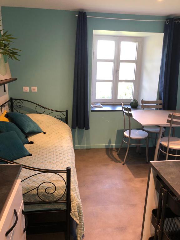 Schlafzimmer mit einem Bett, einem Tisch und einem Fenster in der Unterkunft La maison lilas in Le Pertuis