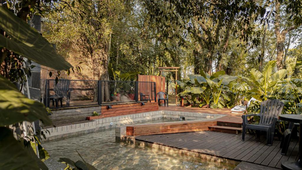 オベラにあるDescanso Verdeのベンチと木々のあるプール付きの裏庭